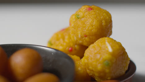 Close-Up-Of-Gulab-Jamun-And-Laddoo-In-Bowls-Celebrating-Muslim-Festival-Of-Eid